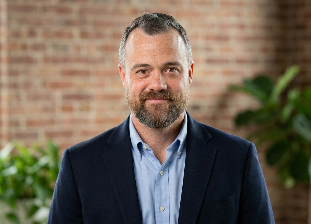 Todd Siegrist in a navy jacket and light blue shirt, in front of a brick wall